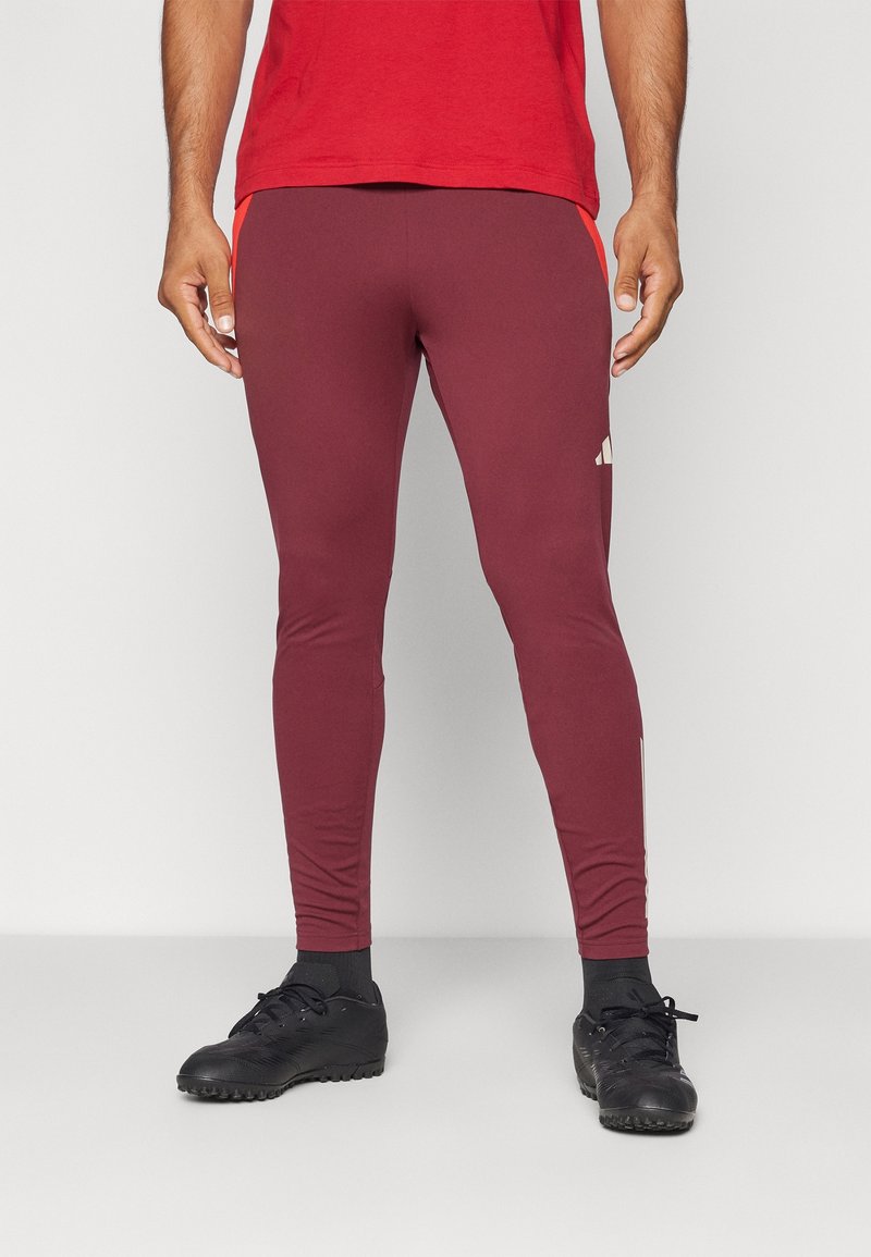 Bordeaux kleurige sportleggings met een strakke pasvorm, voorzien van contrasterende zijstrepen en een logo-detail vlakbij de enkel. Gemaakt van een gladde, rekbare stof.