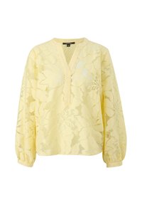 Blouse jaune en dentelle à manches longues avec motif floral, col en V et poignets élastiques.