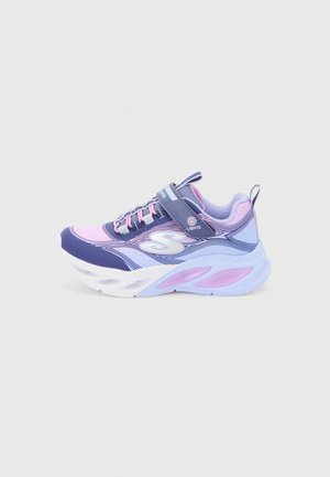 Zapatilla deportiva infantil en tonos púrpura y rosa con suela blanca, cierre de velcro con la etiqueta "Luces", logo lateral y tirador en el talón.