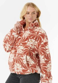 Pull en polaire crème et rouille avec un motif en feuilles, col montant, poche frontale et finitions côtelées.