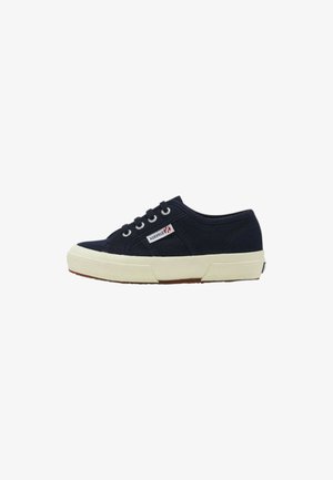 Sneaker bassa in tela blu navy con suola in gomma bianca, chiusura con lacci frontale e piccola targhetta rettangolare con logo sul lato.