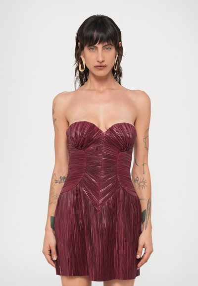 Μπορντό strapless φόρεμα με κάθετες πτυχές, δομημένο μπούστο και φουστάνι με άνοιγμα, που διαθέτει λεία υφή και καθορισμένες ραφές.