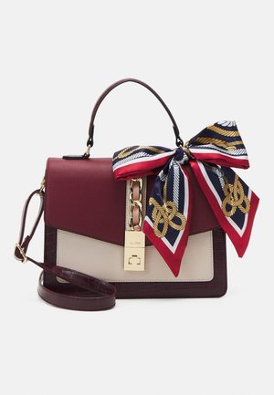 Structured leather handbag in burgundy and beige with gold clasp, top handle, detachable strap, and navy scarf with red and gold rope patterns tied to handle.
