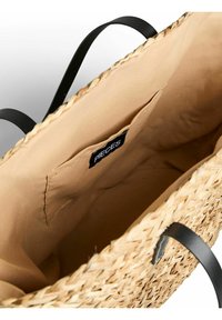 Borsa tote in paglia intrecciata con manici in tessuto nero, dotata di una fodera interna beige e di una piccola etichetta cucita all'interno.
