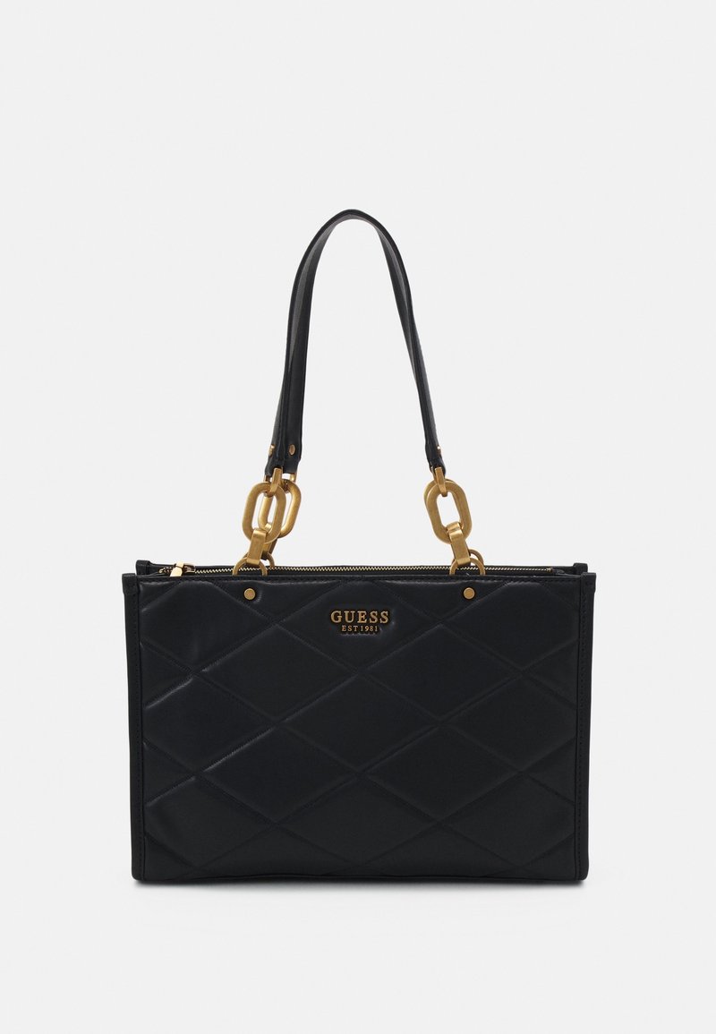 Sac à main matelassé noir avec des maillons de chaîne dorés sur les anses et un logo GUESS doré sur le devant, forme rectangulaire avec fermeture éclair.