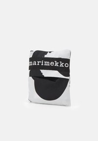 Jastučić s uzorkom u crno-bijeloj boji s izrazitim apstraktnim oblicima. Ima crni pojas s "marimekko" logom sprijeda. Mekani tekstilni materijal.