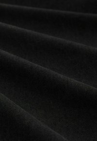 Black fabric with a textured surface, featuring a smooth, woven pattern and draped in gentle folds.