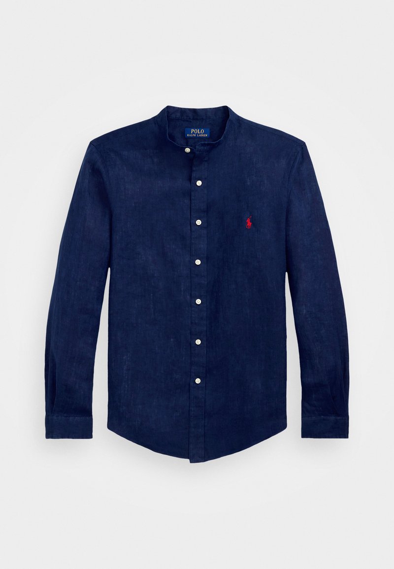 Ναυτικό μπλε λινό πουκάμισο με στάντ γιακά, μακριά μανίκια, κλείσιμο με κουμπιά και μικρό κόκκινο κεντητό λογότυπο στο στήθος.