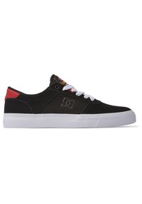 Schwarze Wildledersneaker mit weißen Schnürsenkeln, einem kontrastierenden roten Fersenelement, einem Logo an der Seite und einer weißen Gummisohle.