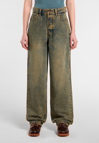 Breda jeans i blekt blått med subtila slitningar. Har hög midja, bälteshällor och klassisk femfickdesign.