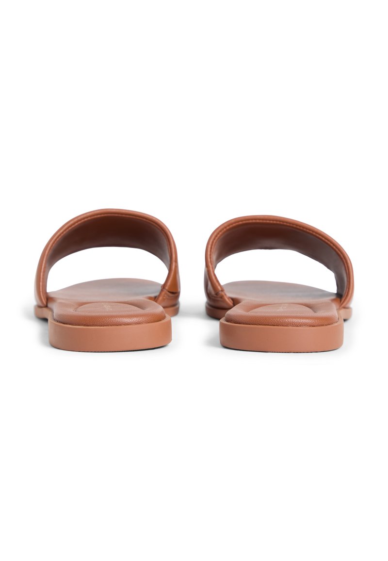 Sandalias marrones tipo slip-on con parte superior sintética suave, correas anchas y plantilla acolchada. Diseño plano y minimalista con bordes redondeados.