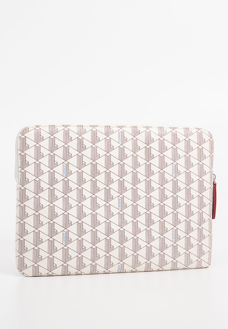 Housse d'ordinateur portable avec un motif géométrique en brun et crème, fabriquée en tissu durable avec une fermeture éclair et un zip rouge en accent.