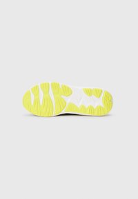 Suela de zapato con una base blanca y acentos de goma amarilla vibrante. Presenta patrones texturizados para un agarre y estabilidad.