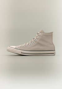 Μπεζ καμβά ψηλό αθλητικό παπούτσι με λευκή λαστιχένια μύτη και σόλα, λευκά κορδόνια και μεταλλικά νημάτια σε ουδέτερο φόντο.