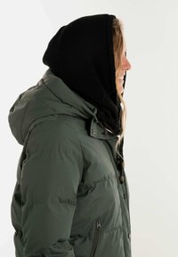 Groene pufferjack met een capuchon en een zwart gebreid binnenvoering. Beschikt over een ritszijzak en bruine knoopaccenten. Zachte textuur.
