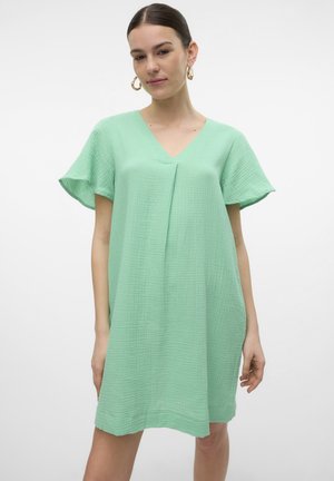 Robe vert clair en tissu texturé, dotée d'un décolleté en V, de courtes manches volantées et d'une coupe ample qui tombe au-dessus des genoux.
