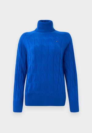 Maglione a collo alto blu lavorato a maglia con un motivo a trecce testurizzato, polsini e orlo a coste, e un piccolo logo sul petto.