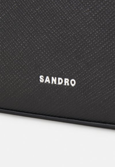 Svart teksturert lær lommebok med preget "SANDRO"-logo i hvitt. Kompakt design med subtil mønstrete overflate.