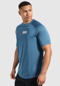Camisa atlética de manga corta azul con un patrón texturizado, con un escote redondo y logotipo impreso en el pecho.