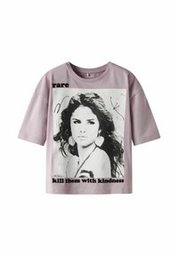 Jasnofioletowy t-shirt z krótkim rękawem, z czarno-białym nadrukiem graficznym przedstawiającym twarz kobiety oraz napisem "rare" i "kill them with kindness."