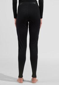 Black leggings with a fitted design, smooth texture, and a waistband featuring a narrow accent band. Ends at the ankle without footwear.