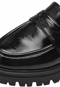Mocassin en cuir noir poli avec une large sangle traversant le cou-de-pied, forme courbée et une semelle en caoutchouc texturée pour l'adhérence.