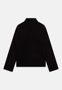 Veste en polaire noire avec un col montant, des manches longues et une silhouette carrée. Pas de fermetures visibles, présente une texture lisse et des coutures propres.