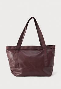 Velika temno rjava usnjena torba z dvema vlaknastima naramnicama in subtilno vtisnjenim imenom blagovne znamke na sprednji sredini.