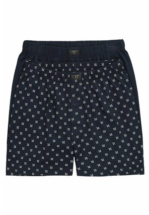 Twee paar donkerblauwe herenboxershorts, één effen en één met kleine witte bloemmotieven, beide met elastische taillebanden.