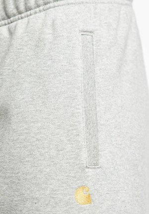 Pantalones de chándal de color gris claro, confeccionados con una tela suave, que cuentan con un bolsillo vertical y un pequeño logotipo bordado en dorado. Cintura elástica para un mejor ajuste.