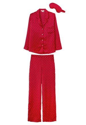 Conjunto de pijama rojo hecho de tela suave, con estampados de corazones blancos. Incluye una camiseta de manga larga con bolsillo y pantalones de pierna ancha, además de una máscara de ojos a juego.
