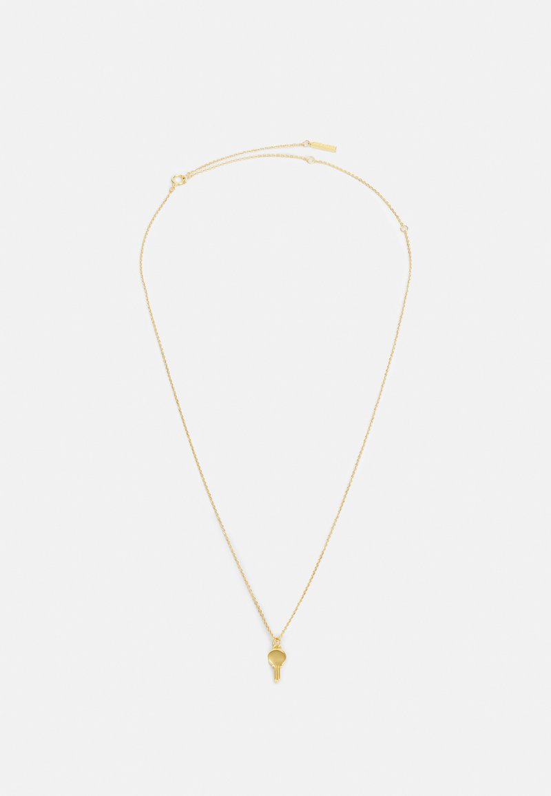 Gold necklace with a fine chain and a small, circular pendant resembling a key or charm, featuring a smooth texture and minimalist design.