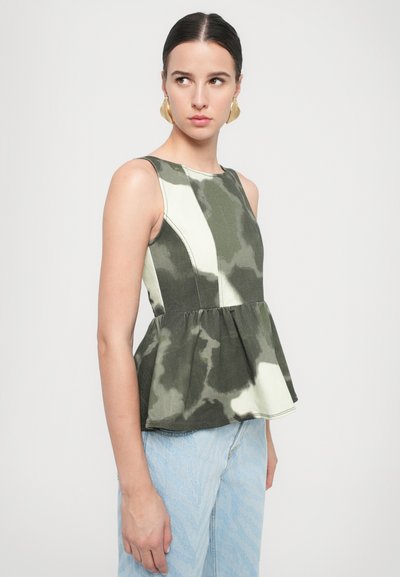 Peplum-toppi vihreässä ja kermavärisessä naamiointikuosissa. Hihaton malli, jossa on rakenteellinen vartalo ja kerätty vyötärö. Denim-kankaan tekstuuri.