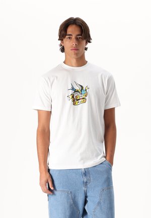 Camiseta blanca de algodón con un gráfico colorido estilo tatuaje de un pájaro con una pancarta que dice "SANTA CRUZ". Mangas cortas y cuello redondo.