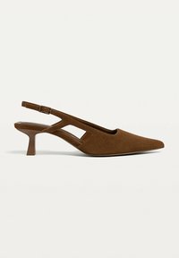 Soulier slingback en daim brun avec bout pointu, petit talon aiguilles bas et bride de cheville réglable sur fond uni.