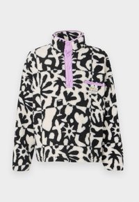 Fleece pullover met zwart-wit bloemenpatroon, paarse drukknoopsluiting, hoge kraag en een kleine voorkant zak met logo label.