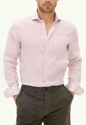 Striped button-up shirt in light pink and white, featuring a collar, long sleeves, and a chest pocket; paired with dark trousers.