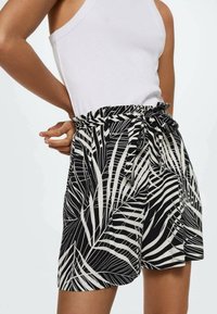 Zwarte en witte korte broek met palmbladerenpatroon en een gestrikt tailleband, gemaakt van lichtgewicht stof, met een elastische taille voor comfort.
