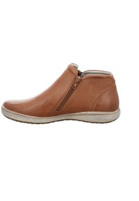 Ruskea nahkainen nilkkabooti, jossa on sivuvetoketju, uritettu päällinen, pyöristetty varvas ja kontrastivärinen valkoinen kumipohja.