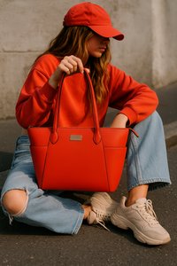 Rode nepleer handtas met twee stevige handvatten, met een rechthoekige vorm en subtiele stikdetails, gecombineerd met een casual outfit.