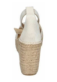 Cream-colored suede high-heeled sandal with a jute platform and ankle strap, featuring stitched detailing and a smooth texture.