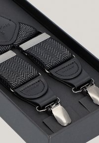 Czarno-szare szelki w wzór rybi ogon z skórzanymi elementami i srebrnymi metalowymi klipsami, zapakowane w czarne pudełko. Teksturowany materiał i solidna konstrukcja.