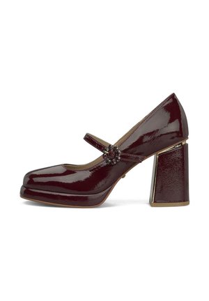 Zapato Mary Jane de charol burdeos con tacón grueso y hebilla decorativa en forma de flor en la correa.