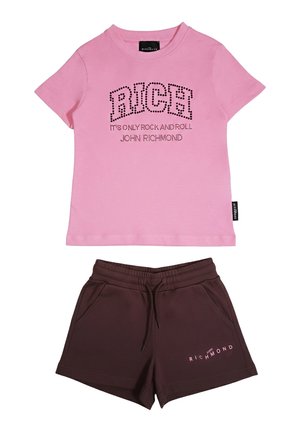 Maglietta rosa a maniche corte con la scritta "RICH" e testo, abbinata a pantaloncini marrone scuro con coulisse, con il logo "John Richmond" sulla gamba sinistra.