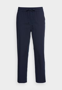 Pantalon bleu marine léger en tissu doux. Comprend une taille élastique avec un cordon de serrage, et un design de jambe fuselée.