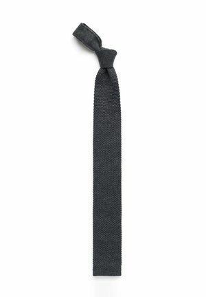 Stickad slips i mörkgrått, med ett strukturerat mönster, smal form och en slingrad knut på toppen. Slät yta utan synlig hårdvara.