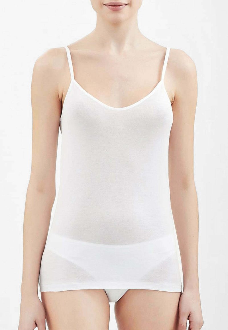 Camisole bianca in cotone con spalline sottili regolabili, design aderente e scollatura a girocollo, con una texture liscia e una sensazione di leggerezza.