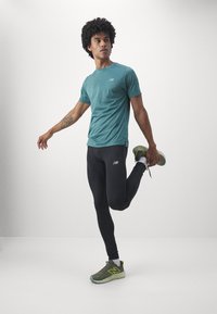 New Balance SLEEK REFLECIVE TIGHT - Leggings - black