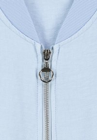 Light blue zip-up jacket featuring a silver zipper, ribbed collar, and smooth texture with tonal stitching along the seams.