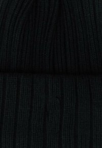Beanie a coste nera con un design texturizzato e orlo ripiegato. Il tessuto appare morbido e caldo, ideale per l'uso in clima freddo.